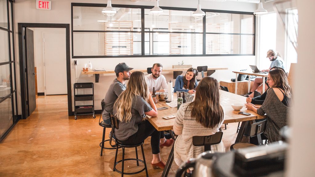 People sat at a meeting around a table. They look like they might be digital types.