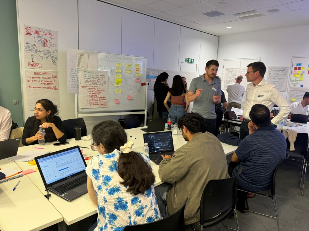 This image shows the Indexing Innovators hack team working together. The team is made up of Birmingham City Council staff, UiPath and Birmingham City University students